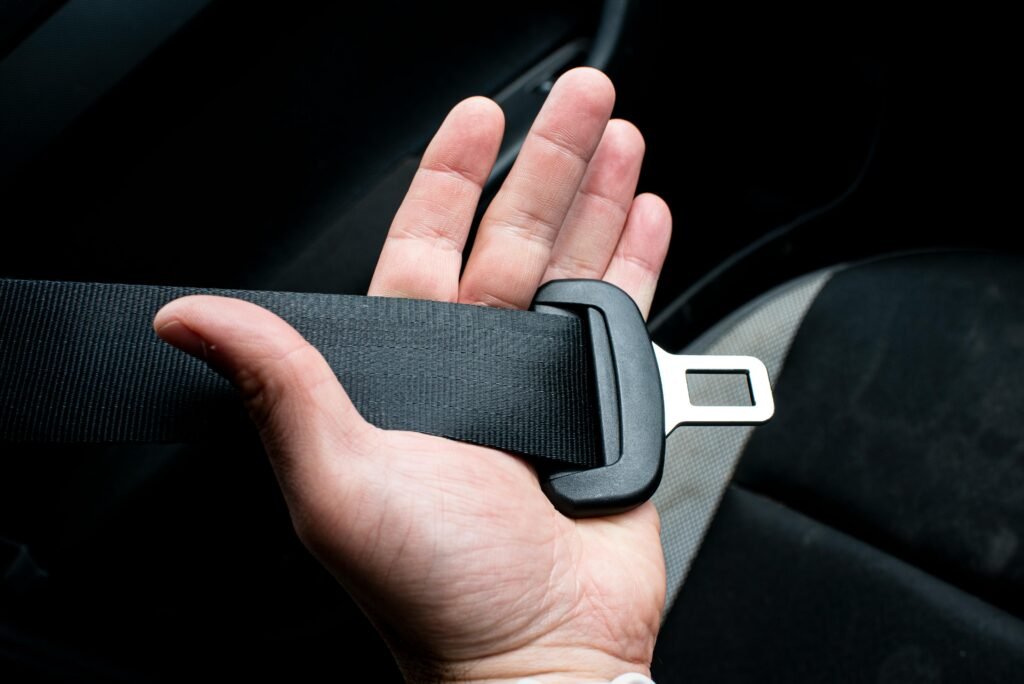 Close-up of a hand holding a car seat belt for safety and security.