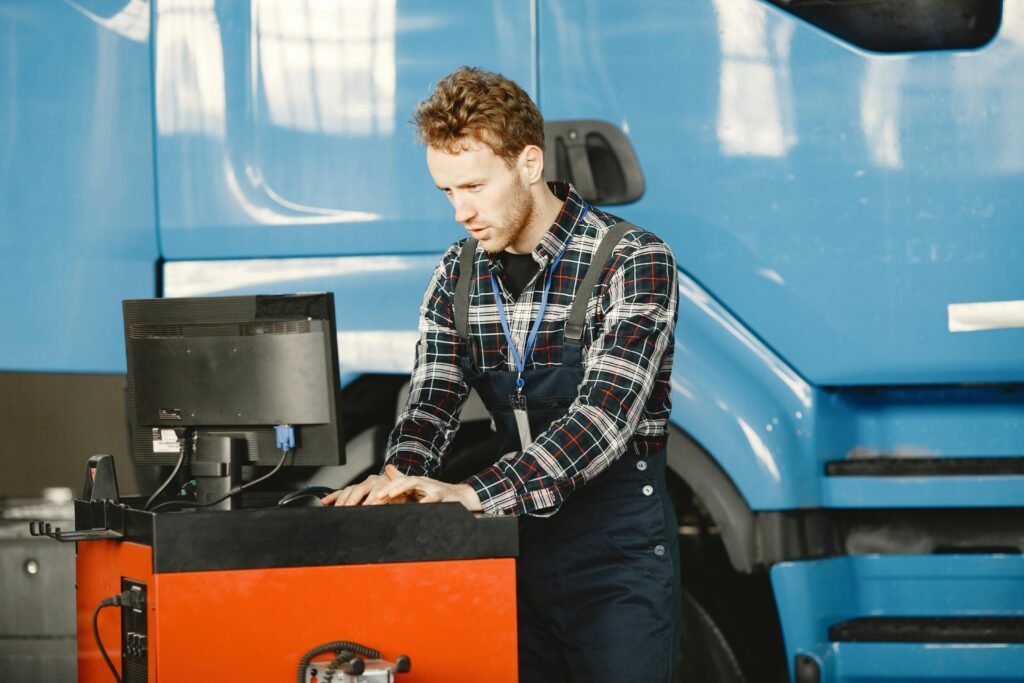 Auto mechanic in a workshop using a computer to diagnose a vehicle.